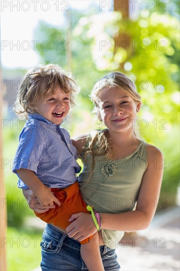 Caucasian girl holding baby brother