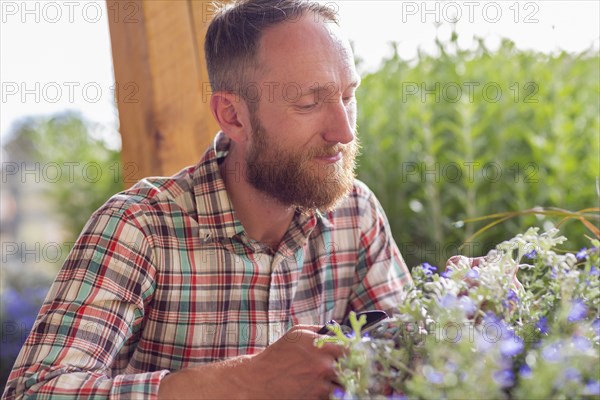 Caucasian man smelling flowers in garden