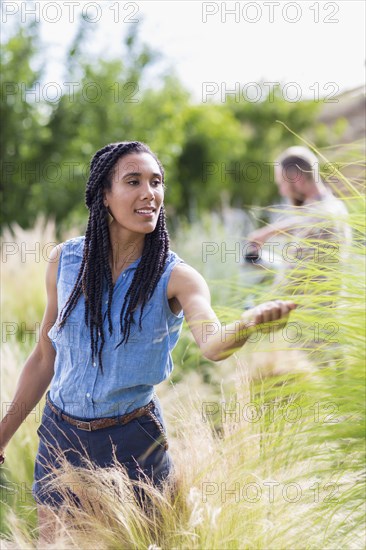 Woman examining tall plants in garden