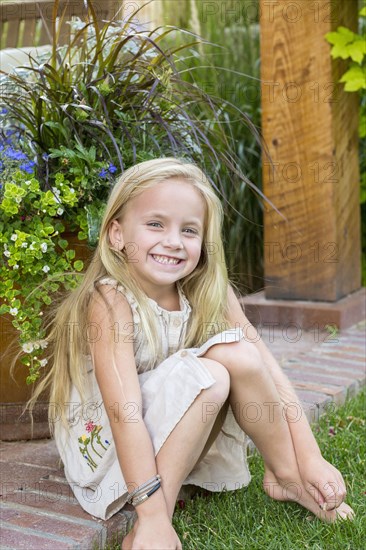 Caucasian girl sitting in backyard