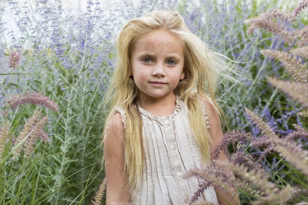 Caucasian girl standing in tall flowers