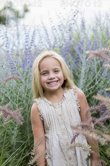 Caucasian girl standing in tall flowers