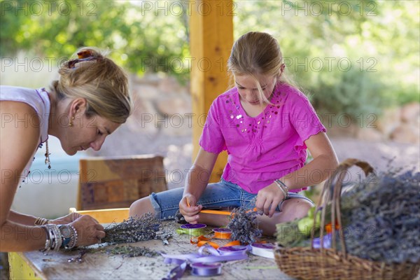 Caucasian mother and daughter making dried flower bundles