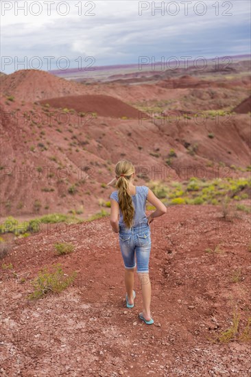 Caucasian girl walking on rural hilltop