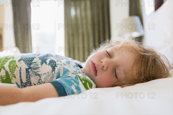 Caucasian boy sleeping on bed