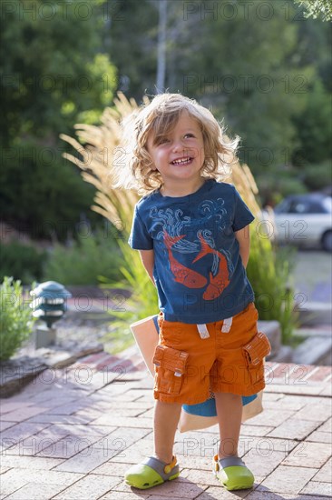 Caucasian toddler hiding gift behind back