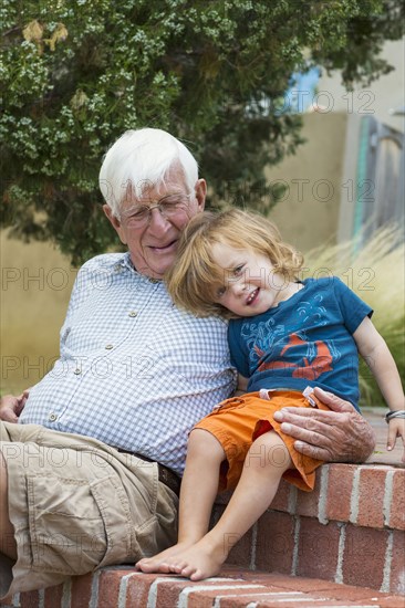 Caucasian grandfather and grandson hugging outdoors