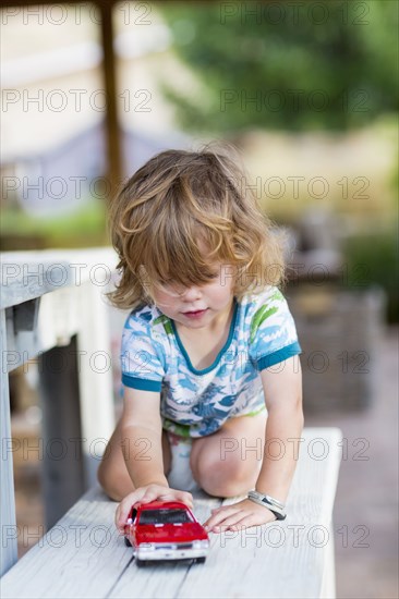 Caucasian boy playing with toy car