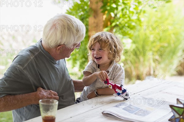 Caucasian grandfather and grandson playing with toy helicopter