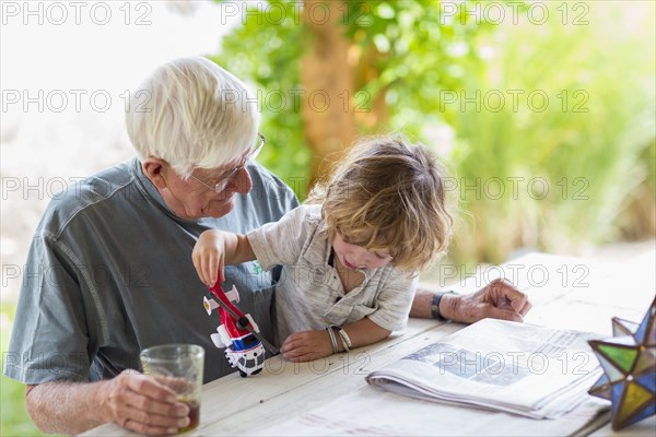 Caucasian grandfather and grandson playing with toy helicopter