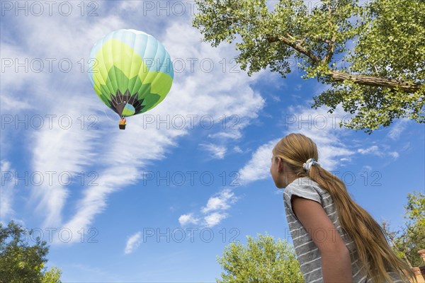 Caucasian girl watching hot air balloon