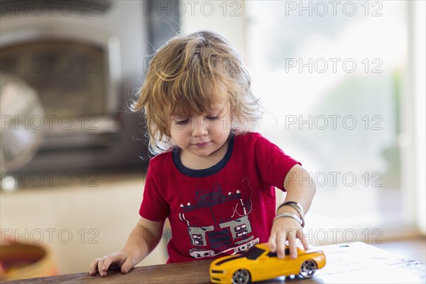 Caucasian boy playing with toy car