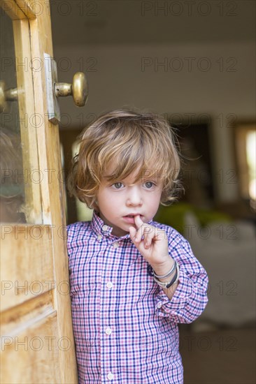 Caucasian boy looking out open door