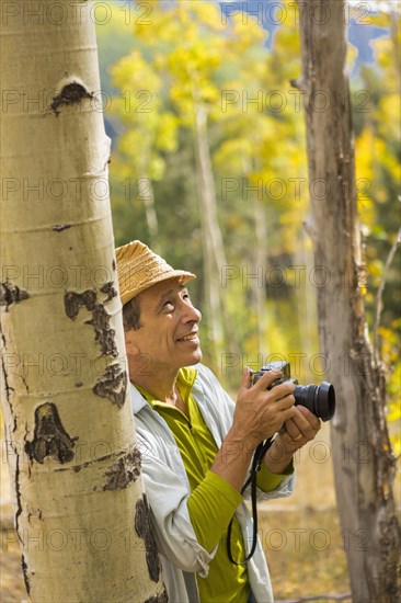 Man photographing with camera in autumn forest