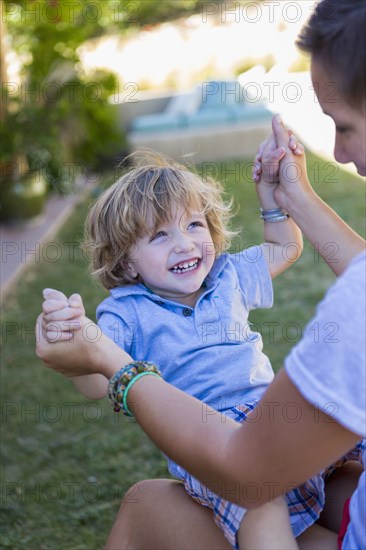 Mother playing with son in backyard