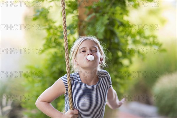 Caucasian girl blowing bubble gum bubble