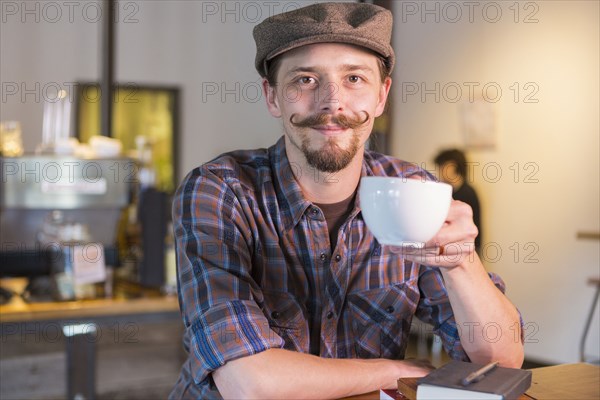 Caucasian man drinking coffee in cafe