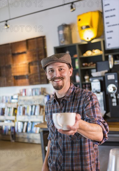 Caucasian barista serving coffee in cafe