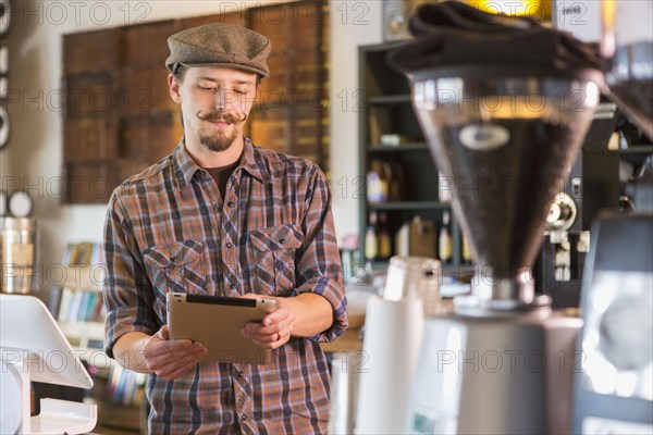 Caucasian man using digital tablet in cafe