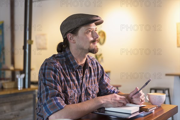 Caucasian student doing homework in cafe