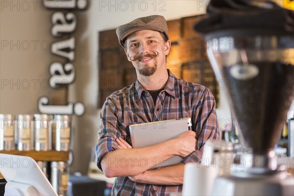 Caucasian barista holding digital tablet in cafe