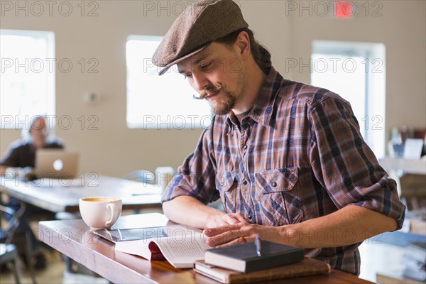 Caucasian student reading in cafe