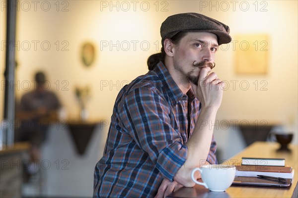 Caucasian man thinking in cafe