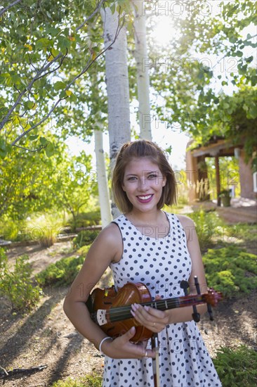 Mixed race musician holding violin outdoors