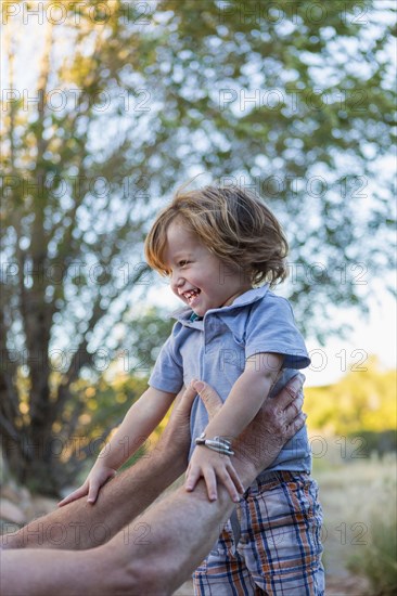 Caucasian grandfather holding grandson outdoors