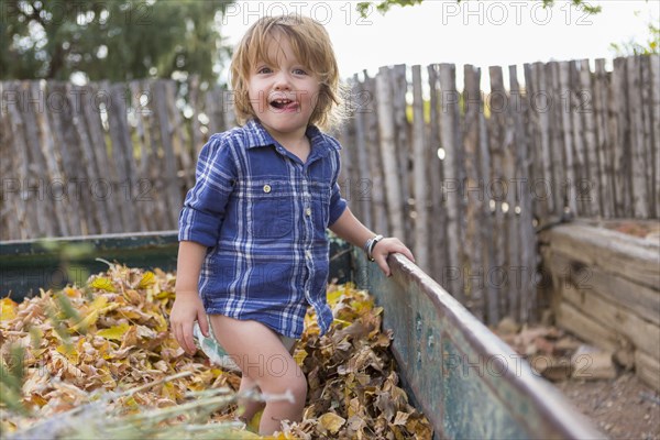 Caucasian boy standing in autumn leaves