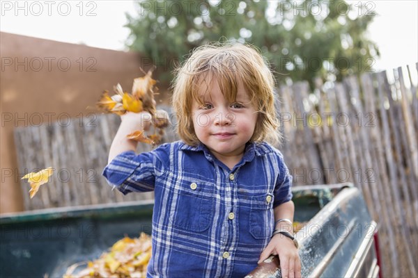 Caucasian boy playing in autumn leaves