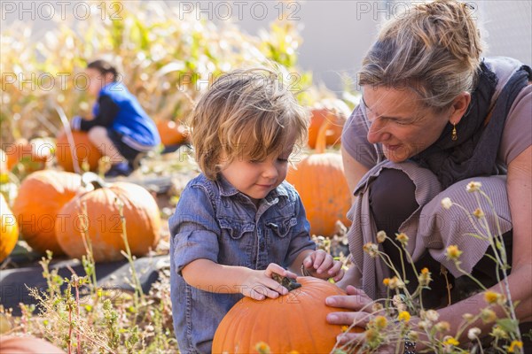 Caucasian mother and son in pumpkin patch
