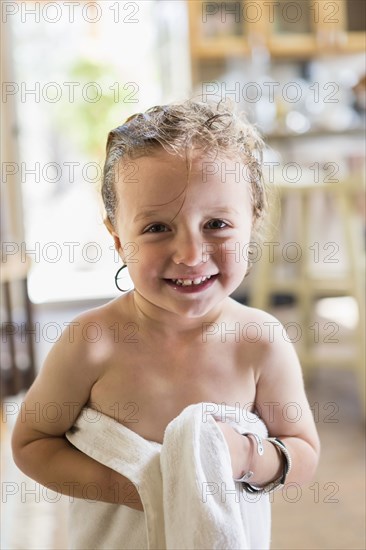 Caucasian boy wrapped in towel