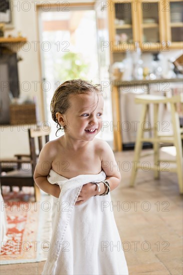 Caucasian boy wrapped in towel