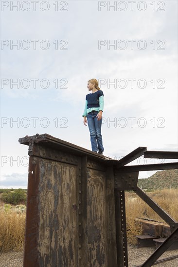 Caucasian girl climbing rusty structure outdoors