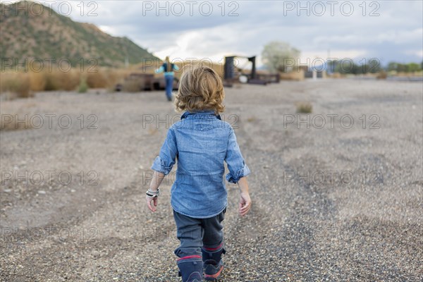 Caucasian boy walking in gravel