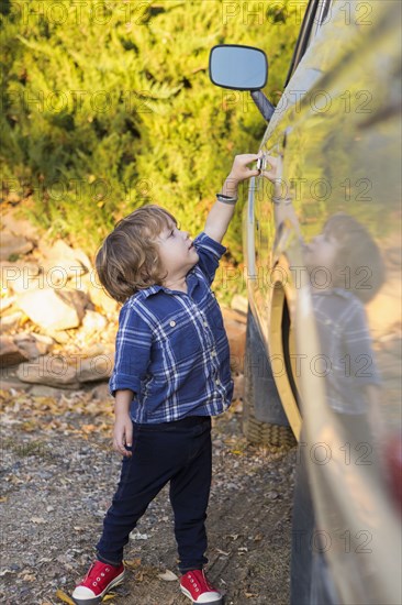 Caucasian boy opening car door