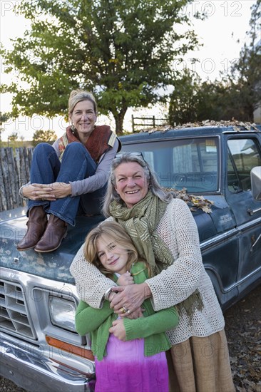 Three generations of Caucasian women sitting on truck