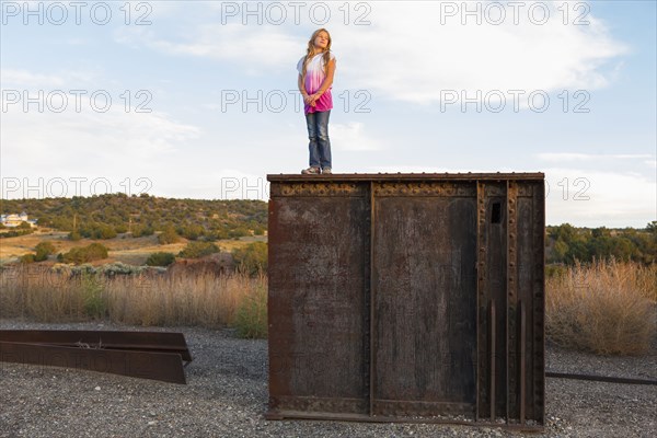 Caucasian girl standing on rusting structure outdoors