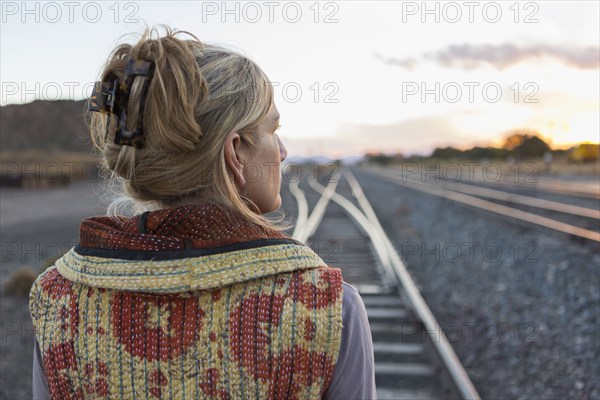 Caucasian woman standing on train tracks