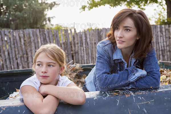 Mother and daughter sitting in truck bed