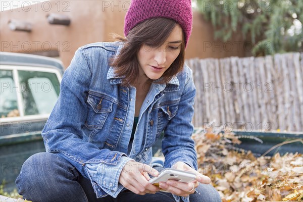 Hispanic woman using cell phone in truck bed