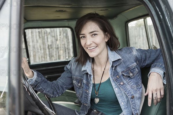 Hispanic woman sitting in truck