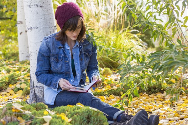 Hispanic woman reading in garden