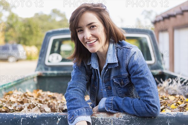 Hispanic woman sitting in truck bed