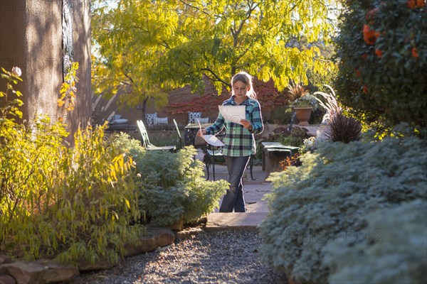 Caucasian girl reading in backyard