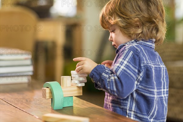 Caucasian boy playing with wooden blocks