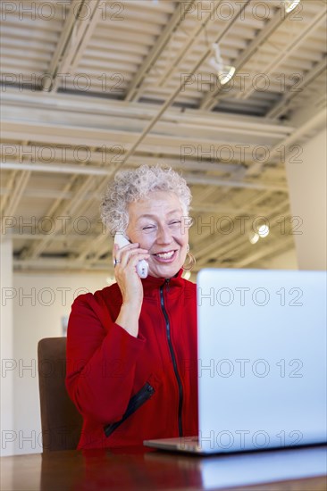 Older mixed race woman working in art gallery