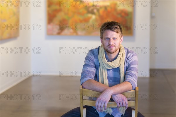 Caucasian man sitting in art gallery