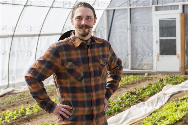 Caucasian farmer standing in greenhouse